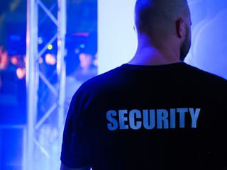 Agent de sécurité en tenue devant l'entrée d'un site surveillé